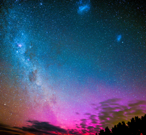 Klarer Nachthimmel über Neuseeland mit unzähligen Sternen, Milchstraße und leuchtenden Farben der Aurora.