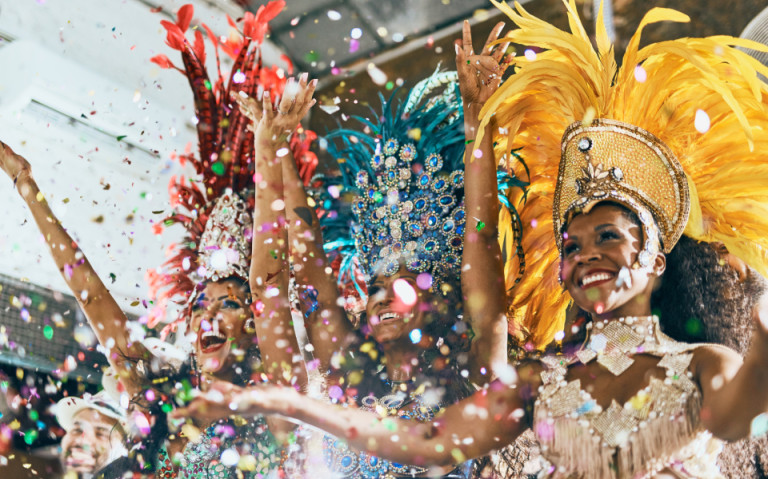 Schnappschuss schöner Samba-Tänzer, die mit ihrer Band auf einem Karneval auftreten.