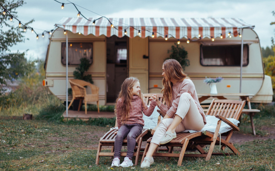 Mutter mit Tochter vor einem Wohnwagen